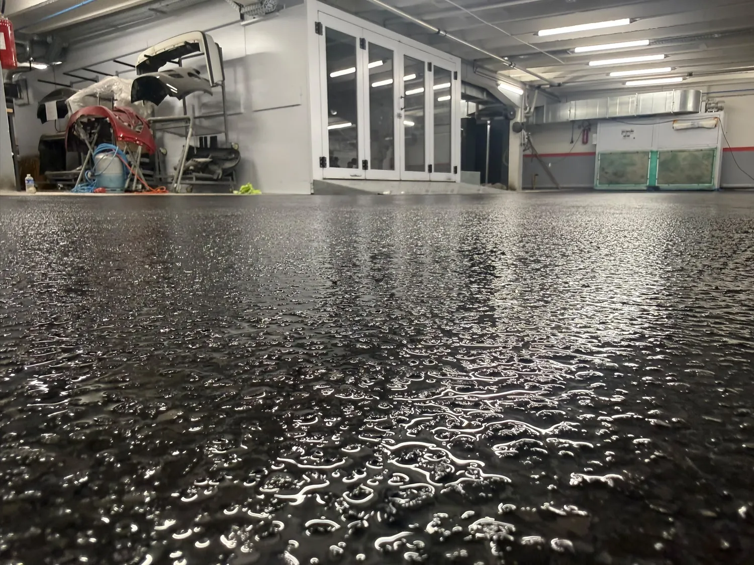 Sol à flocons de vinyle noirs et gris dans un atelier, vu au ras du sol