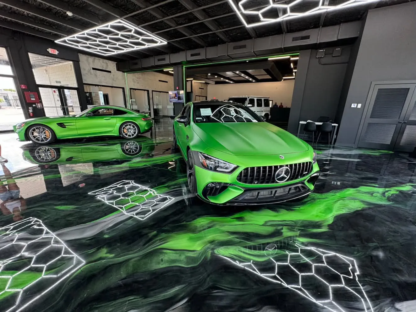 Sol en résine métallique verte dans un showroom avec lignes hexagonales