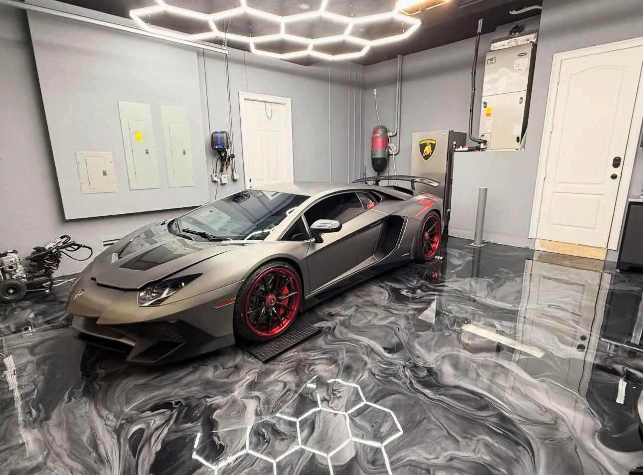 Sol en résine métallique grise dans un garage avec plafond lumineux hexagonal